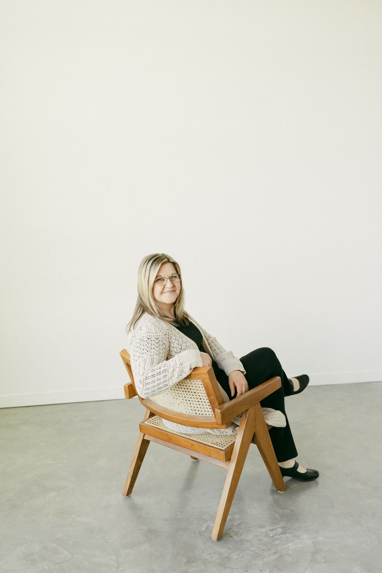 Jody Beagle, executive function and neurodivergence consultant based in Diamond Valley, Alberta, seated in a wooden chair